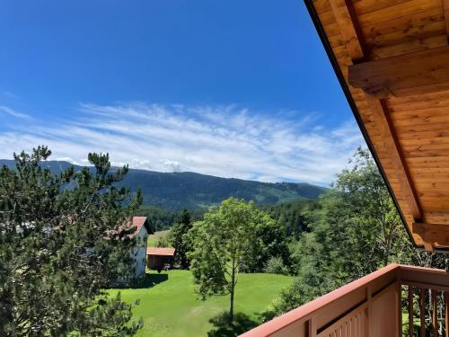 desde el balcón de una casa con un patio verde en Appartamento La Téza, en Lavarone