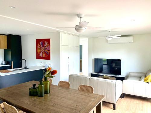 Una cocina y una sala de estar con una mesa y un sofá. en Grampians View Retreat, en Halls Gap