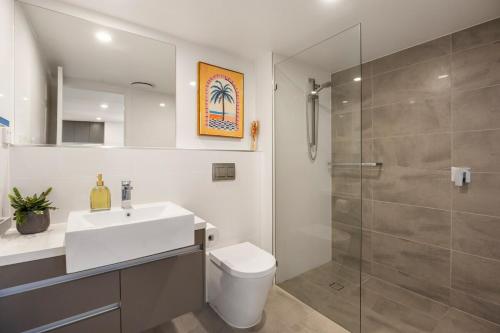 a bathroom with a toilet and a sink and a shower at Lux1BR Near Stadium, Parking & Balcony in Brisbane