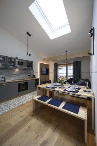 a large kitchen with a table with blue mats at Haus Sternenhimmel in Oberammergau