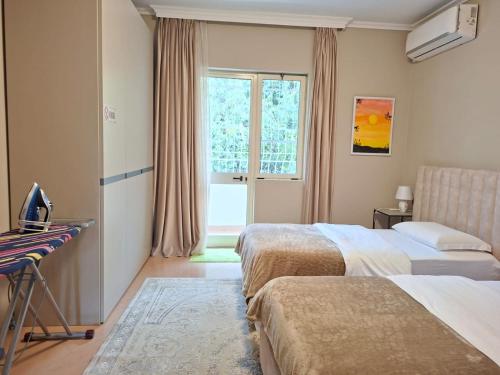 a hotel room with two beds and a desk and a window at Villa Chaplin in Tirana