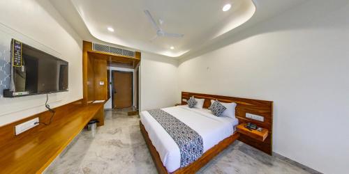 Un dormitorio con una cama y un televisor de pantalla plana. en KING'SWAY Hotel, en Dūngarpur