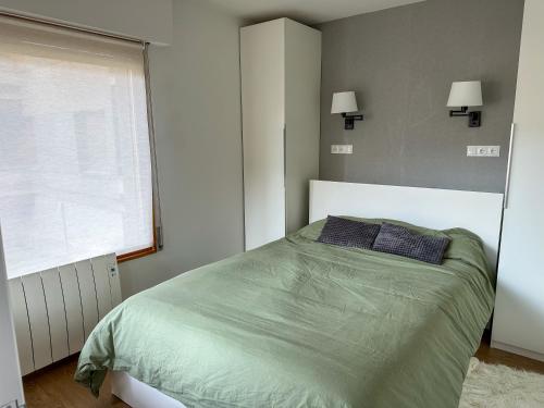 een slaapkamer met een groen bed en een raam bij NEGUA Vielha in Vielha
