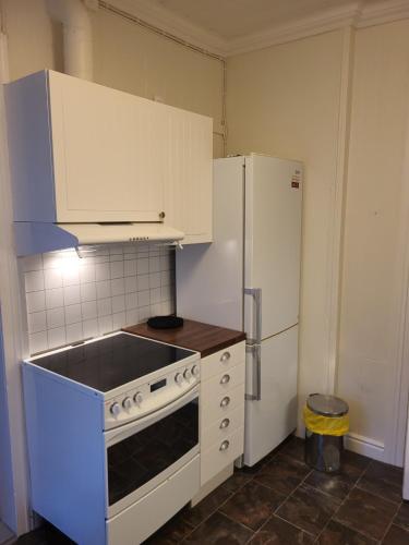 una cucina con piano cottura bianco e frigorifero di 3 roms leilighet Narvik sentrum a Narvik