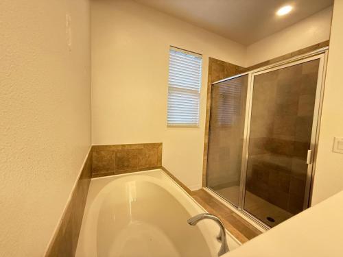 ein Badezimmer mit großer Badewanne und Dusche in der Unterkunft Orlando Dream Escape in Saint Cloud