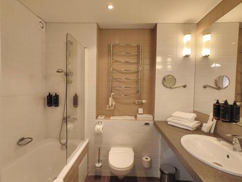 une salle de bain avec une baignoire, des toilettes et un lavabo dans l'établissement Mercure Marijampole, à Marijampolė