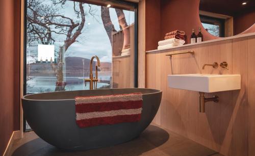 Un baño con una bañera grande y un lavabo. en Isle of Raasay Distillery, en Raasay