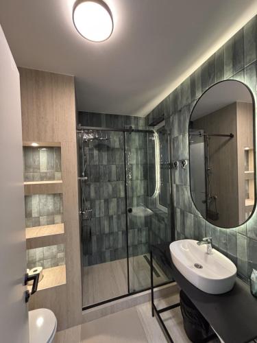 a bathroom with a sink and a shower with a mirror at Urban Nest Belgrade in Belgrade