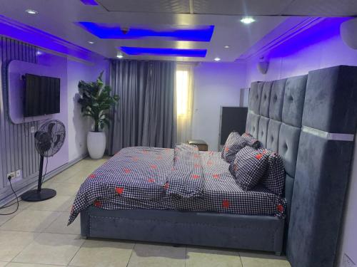 Un dormitorio con una cama en una habitación morada. en Chibuzor Apartment, en Lagos