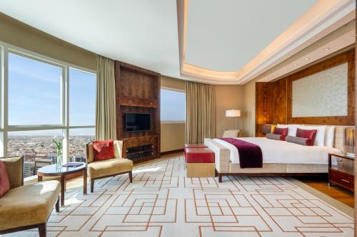 a hotel room with a bed and a large window at Grand Millennium Al Wahda Executive Apartments in Abu Dhabi