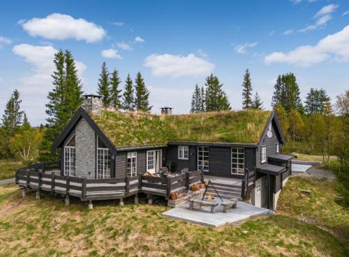 ein großes schwarzes Haus mit Grasdach in der Unterkunft Spacious Family Cabin In Western Golsfjellet in Gol