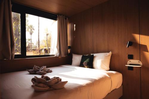 a bedroom with a bed with two bowls on it at Les Prairies de la Mer in Grimaud