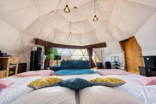 une chambre avec deux lits dans une tente dans l'établissement Yufuin Hanarenoyado Yukagetsu, à Yufu