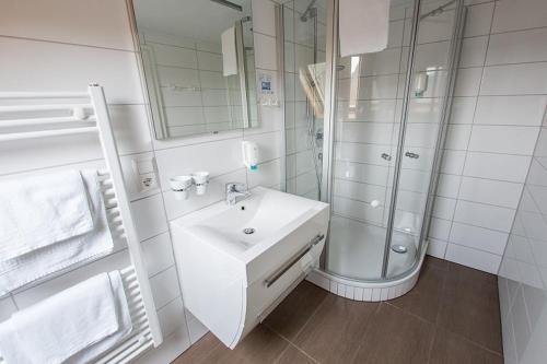 Un baño blanco con lavabo y ducha en Hotel Sewenig, en Müden