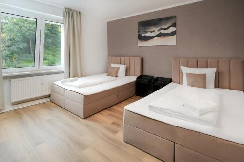 a hotel room with two beds and a window at SHIN APARTMENTS in Essen