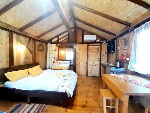 a bedroom with a bed and a desk in a room at Tiny houses Genacvale in Martvili
