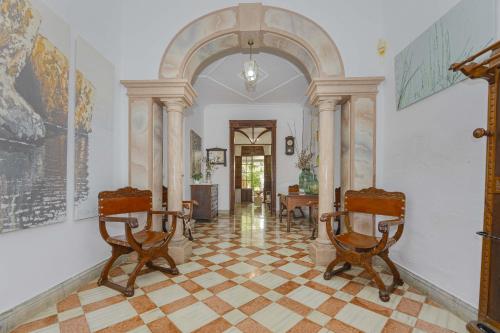 un couloir avec deux chaises et une arche dans l'établissement Casa de Can Virolla Gran, à Sa Pobla
