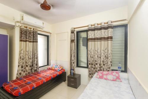 ein Schlafzimmer mit einem Bett und zwei Fenstern in der Unterkunft Ac Bed with breakfast At ovale naka ghodbunder road thane west in Thane
