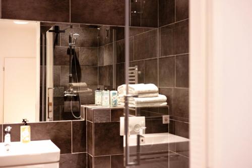 a bathroom with a sink and a toilet and a shower at De Eindhovenaar City Apartments in Eindhoven