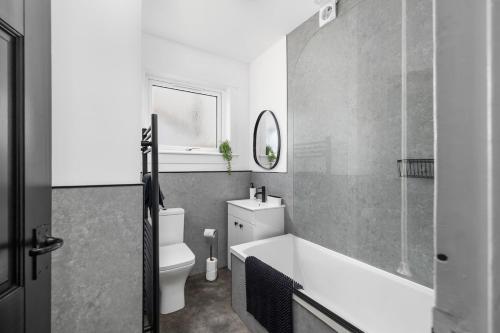 une salle de bain avec une baignoire, des toilettes et un lavabo dans l'établissement 3BR spacious central home in a quiet location, à Montrose
