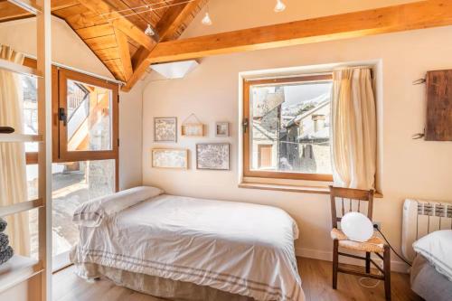 um quarto com uma cama e uma janela em El Pajar de la Leña - tucasaenlospirineos em Sandiniés