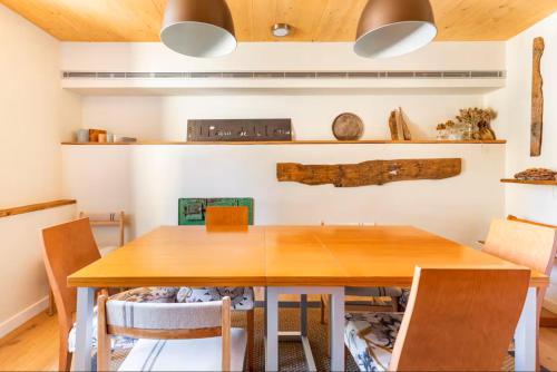 uma sala de jantar com mesa e cadeiras de madeira em El Pajar de la Leña - tucasaenlospirineos em Sandiniés