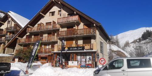 a building in the snow with a car parked in front at Foux d'Allos, studio de 27m2 en centre-ville, plein sud avec terrasse in La Foux d'Allos