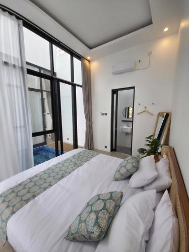 una camera da letto con un letto grande con una grande finestra di Mai House Jogja a Piyungan