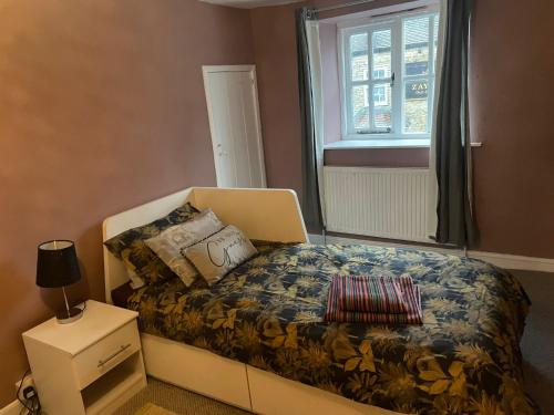 a small bedroom with a bed and a window at Fox Haven in Bicester