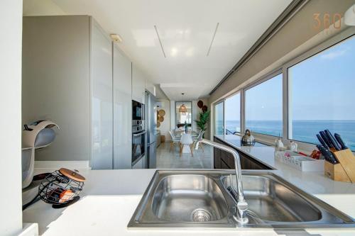 Η κουζίνα ή μικρή κουζίνα στο Luxury 3BR Seafront Duplex with Pool, Jacuzzi & Views by 360 Estates