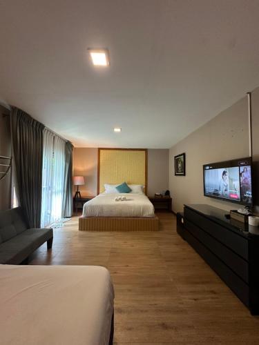 ein Hotelzimmer mit einem Bett und einem Flachbildfernseher in der Unterkunft Good Mood Resort in Ko Lipe