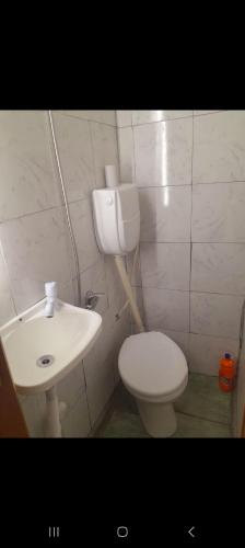 Un baño con un inodoro blanco y un lavabo. en Playa mansa, en Atlántida