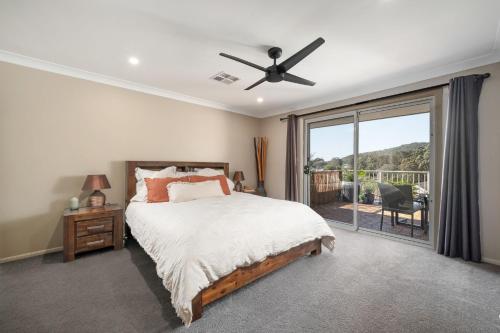 a bedroom with a bed and a sliding glass door at Luxury at Lagoon Estate in Nelson Bay