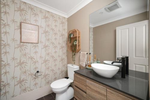 a bathroom with a white toilet and a sink at Luxury at Lagoon Estate in Nelson Bay