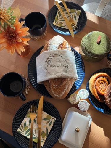 ein Tisch mit Tellern Brot und Besteck darauf in der Unterkunft Casa Oliva Tokaj in Tokaj