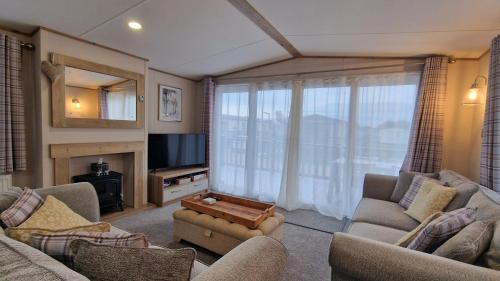 a living room with two couches and a tv at The Good Life, The Boulevard, Selsey in Selsey