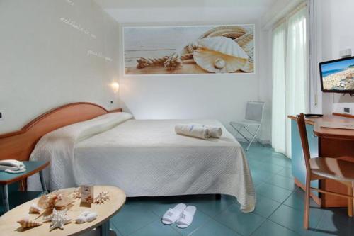 a bedroom with a bed and a table and a desk at HOTEL AURORA in Cattolica