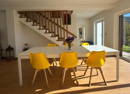 a dining room with a white table and yellow chairs at Chez Daniela in Cerva
