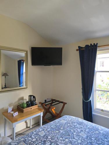 - une chambre avec un lit et une télévision murale dans l'établissement Cozy Double Room - The Unicorn Hotel, à Llanidloes