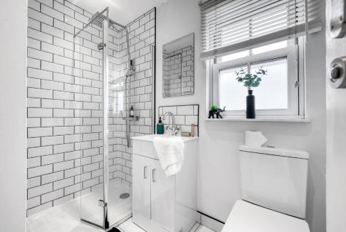 a white bathroom with a shower and a sink at Deppers Bridge, 3 Bedroom Property 