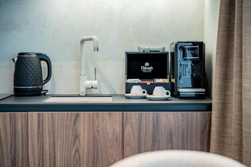 a kitchen counter with a sink and a coffee maker at Novita Hotel in Sofia