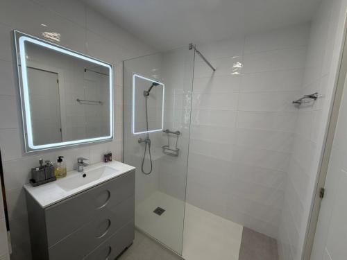 a bathroom with a shower and a sink and a mirror at The White Pearl Marbella in Marbella