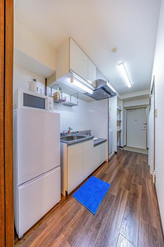 a kitchen with white appliances and a blue rug at オーシャンビュー窓から見える景色を思い出に The琉球タワー10F in Yonabaru