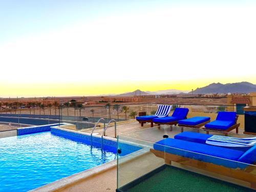 a pool with blue chairs and a view of the desert at The View - Luxury One bedroom Apartment in Sharm El Sheikh