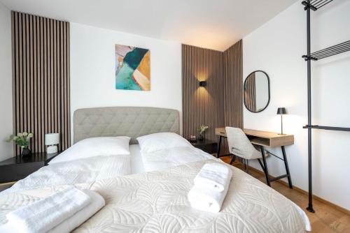 多瑙河畔克雷姆斯Sweet Apartments - Krems an der Donau的一间卧室配有两张白色的床和一张书桌