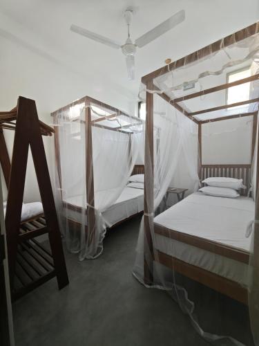 two bunk beds with mosquito nets in a room at Asoka's Place in Unawatuna