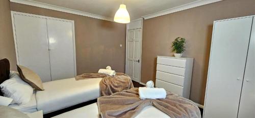 a bedroom with two beds with blankets and a dresser at The Kilnwood House - 3 Bed w Free Parking and Fast WiFi - Contractor Ready in Crawley