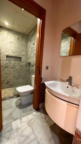 a bathroom with a tub and a toilet and a sink at Beautiful appartement with pool view in Mohammedia