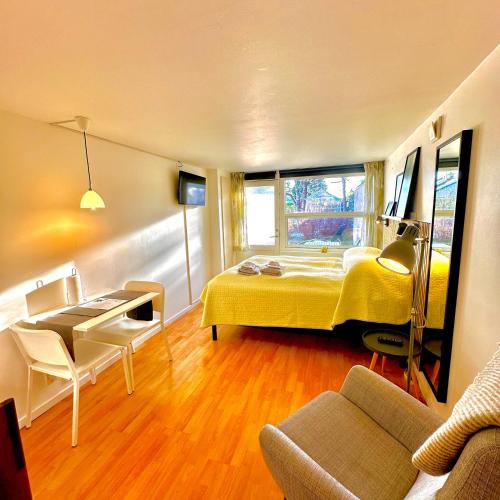 a bedroom with a yellow bed and a couch at Cosy apartment with private terrace in Vallensbæk