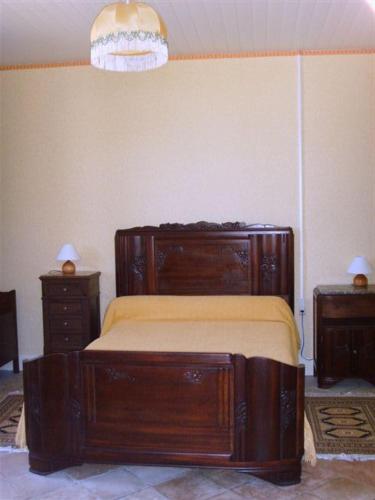 a bedroom with a wooden bed and two night stands at La Plaine in Vaissac